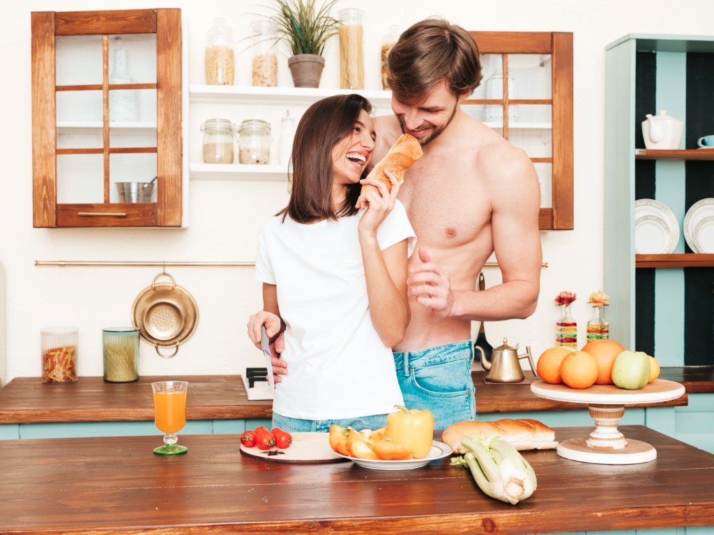 Beautiful woman and handsome man posing in the kitchen