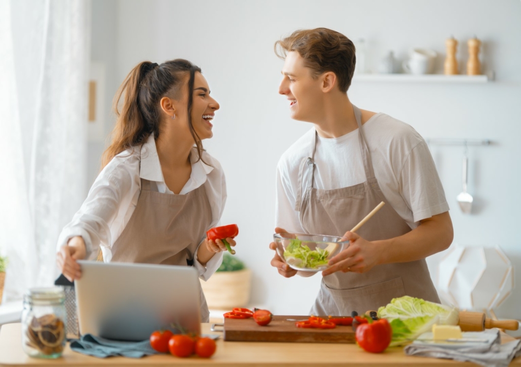 Healthy food at home. Happy loving couple is preparing the proper meal in the kitchen.